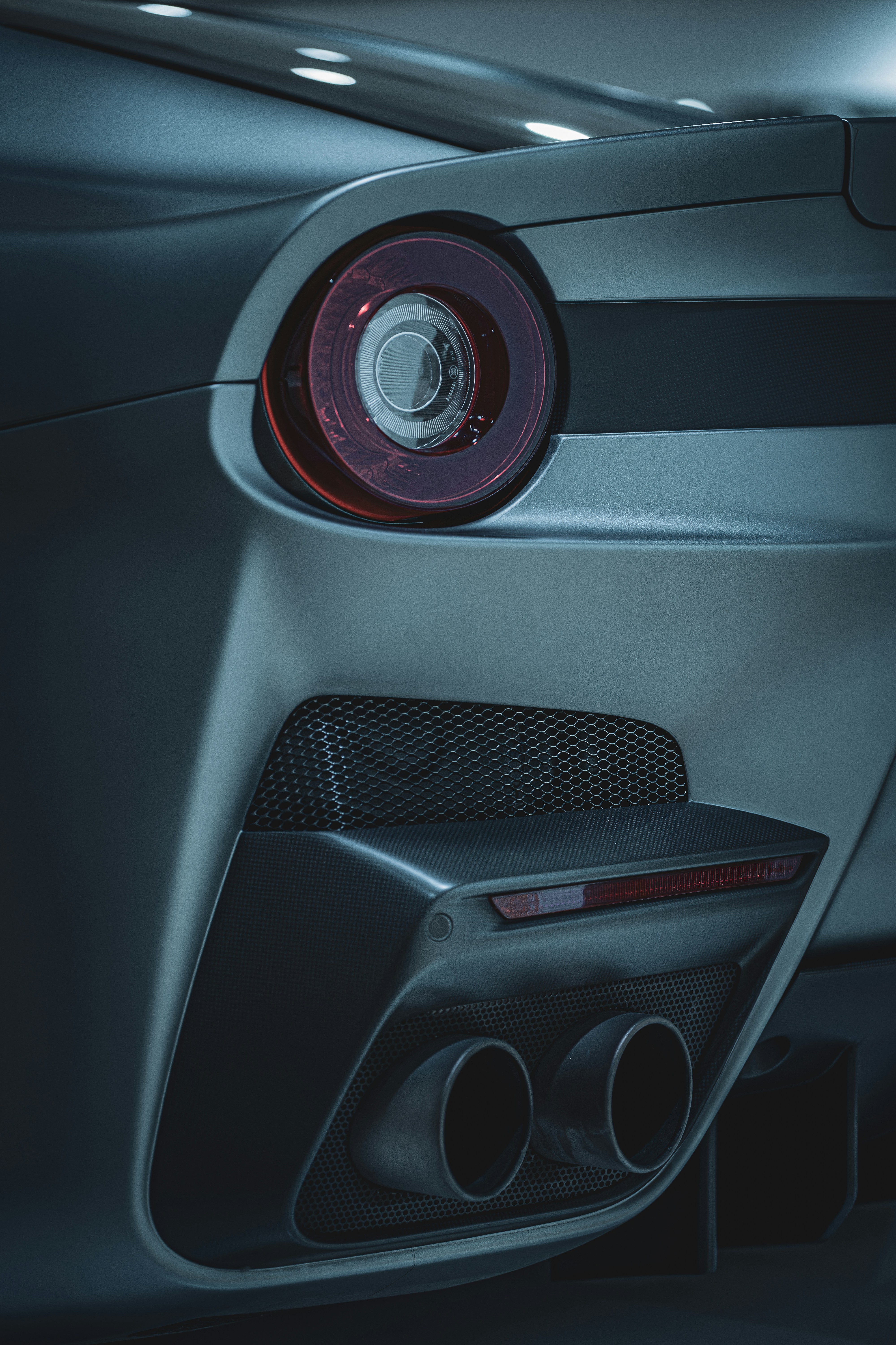 Close-up of car exhaust and taillight details in grey tones